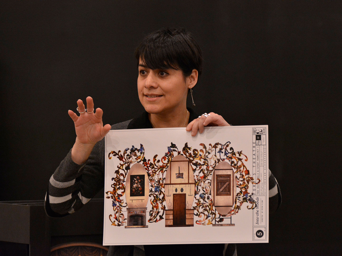 A female scenic designer holds up a rendering of the set for a stage production of 'Into the Woods" at Ford's Theatre.