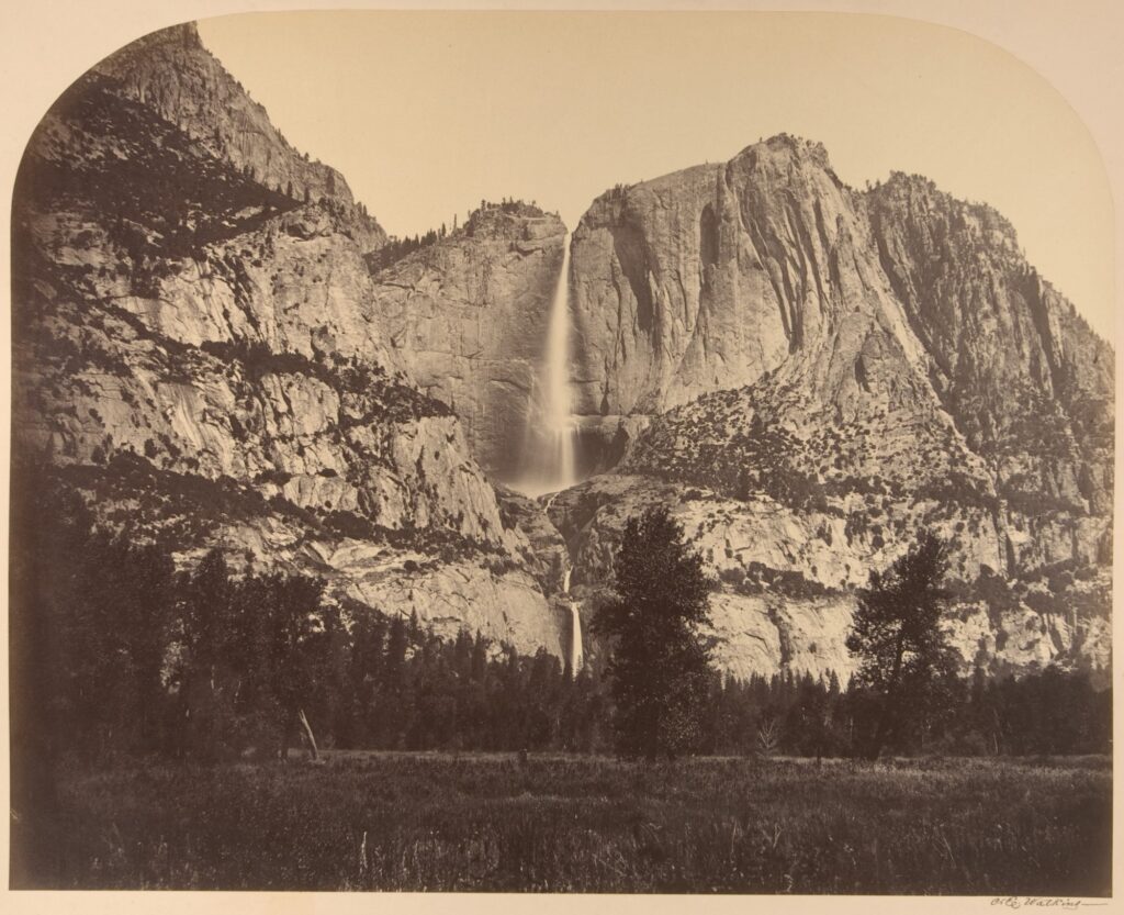 Black and white photograph of a waterfall among the cliffs of Yosemite National Park.