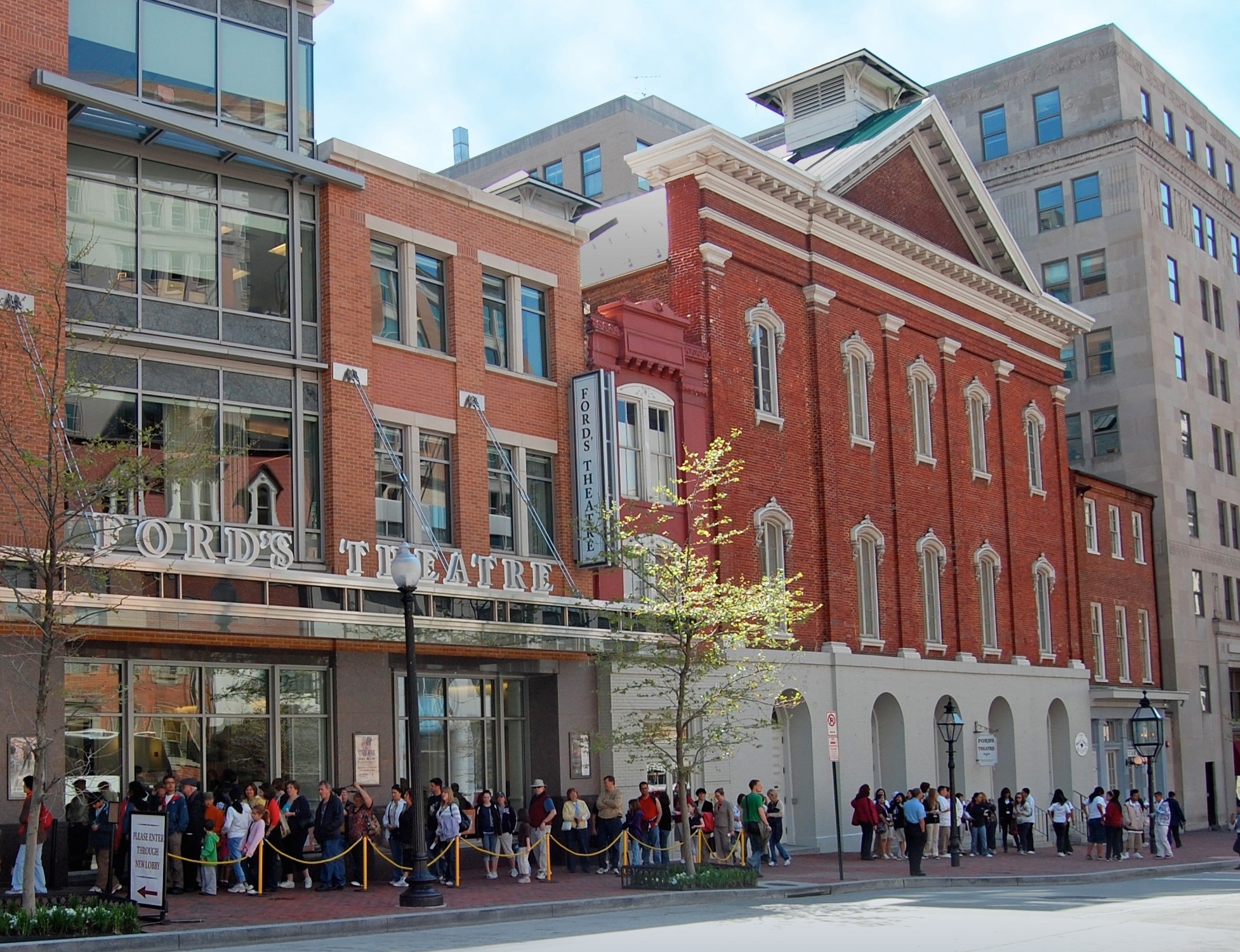 Exterior image of Ford's Theatre today. Image shows a line of visitors stretching down Tenth Street NW. 