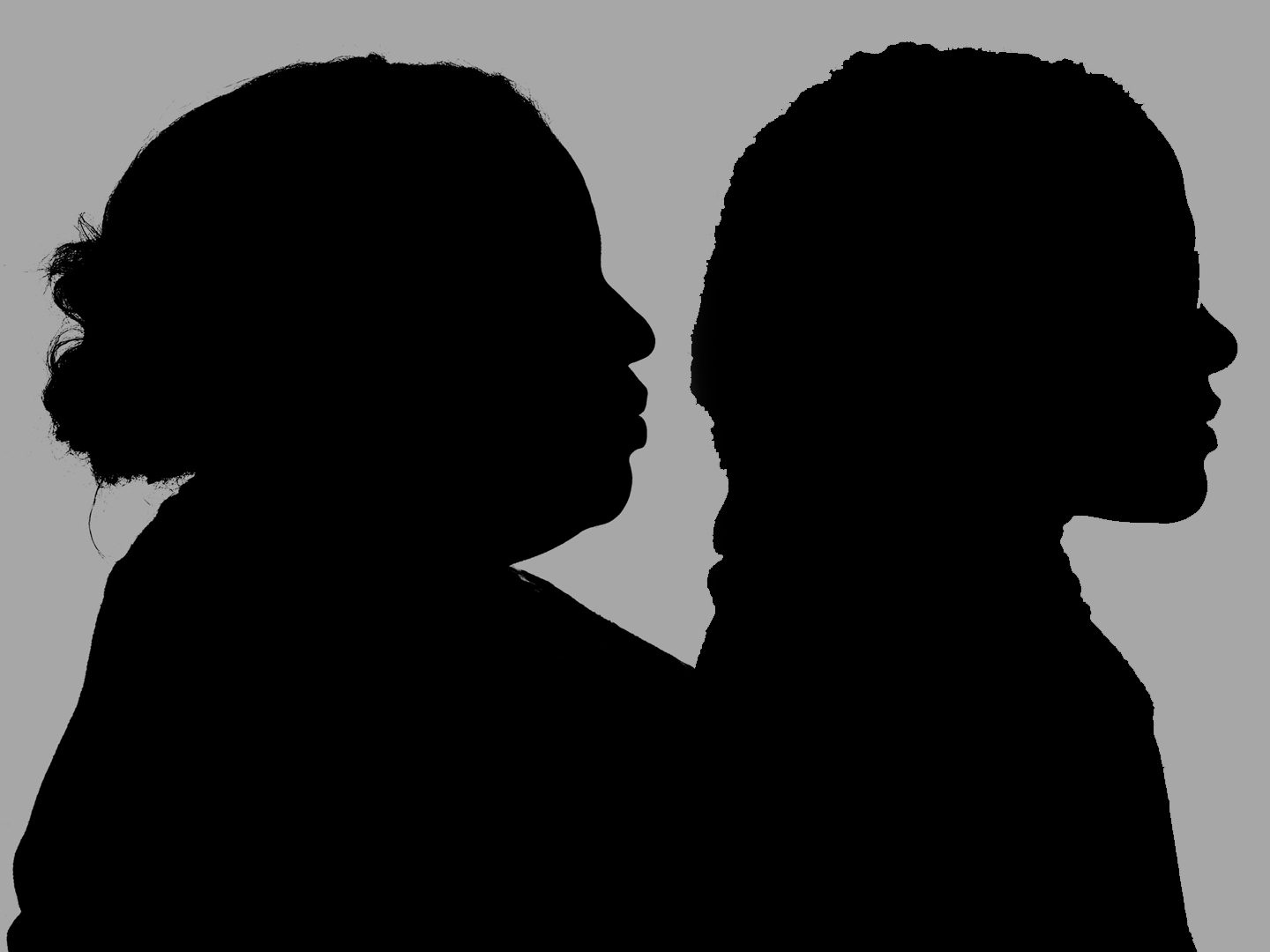 Silhouette of two Black women against a gray background.