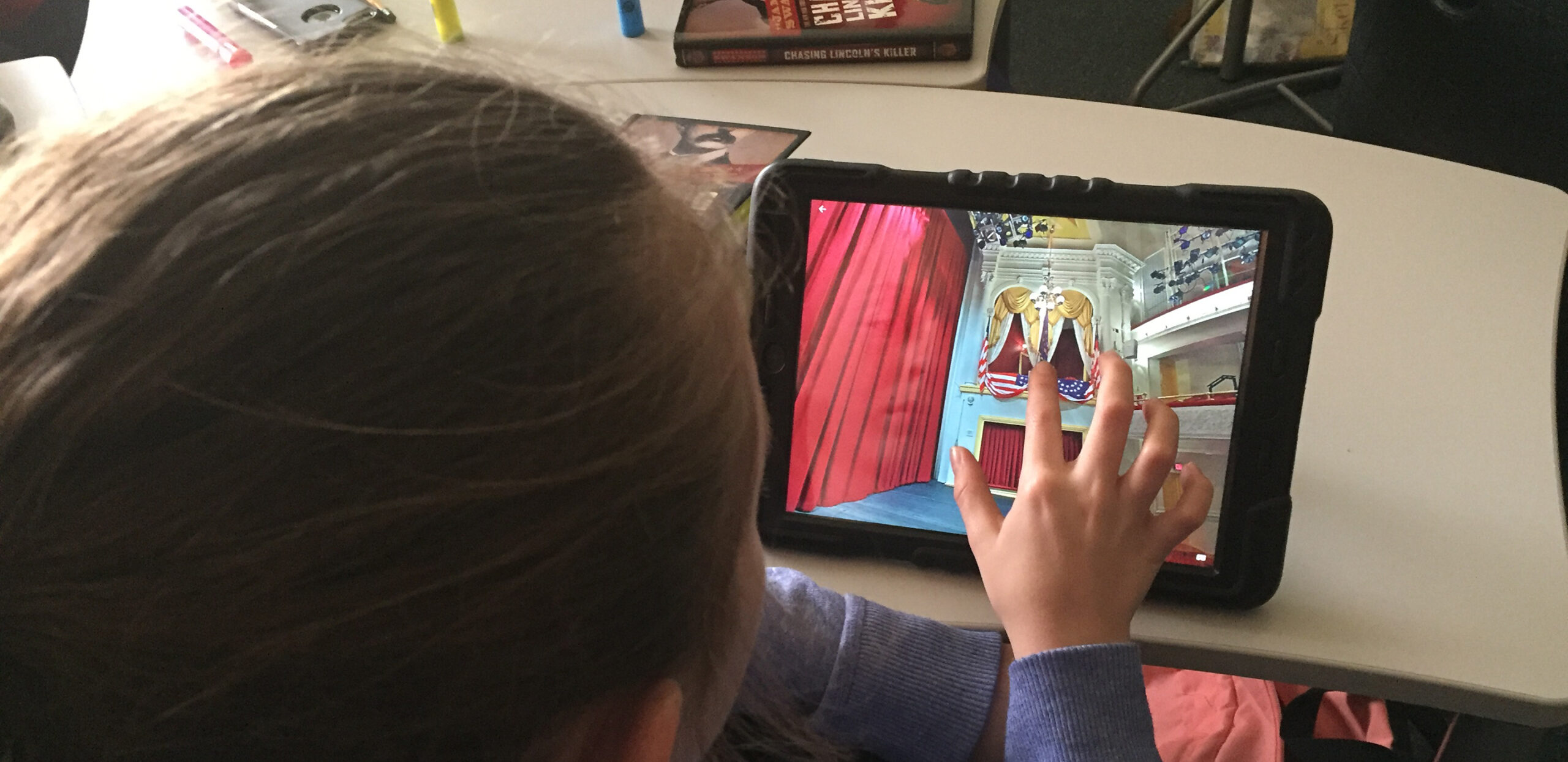 A girl explores a virtual tour of Ford’s Theatre on a tablet computer.