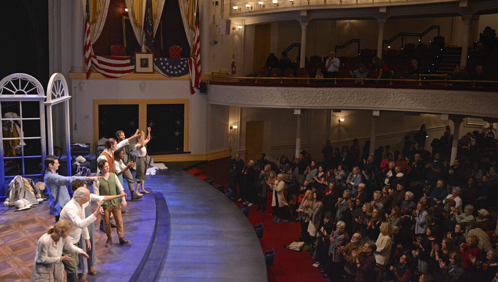 Cast members wave and bow in a line on stage at Ford’s Theatre following a performance.