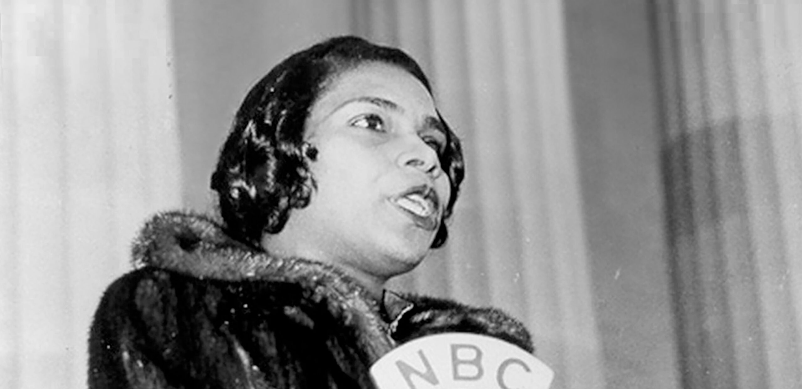 Singer Marian Anderson stands singing behind a podium at the Lincoln Memorial in Washington, D.C.