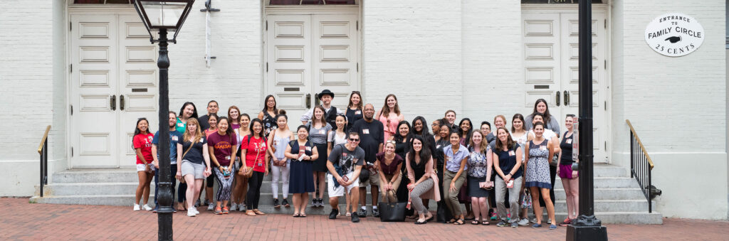 A diverse group of tour attendees pose on the steps of Ford’s Theatre with an actor dressed as Detective James McDevitt.