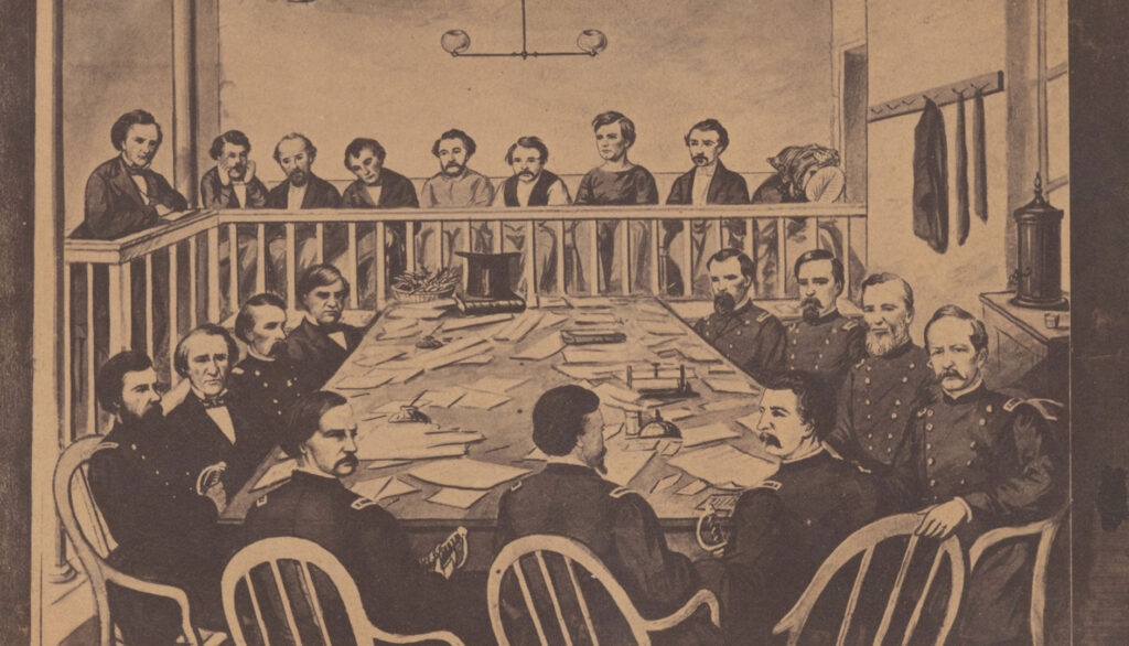 Drawing from a courtroom. A number of men sit around a table full of documents. Other men sit behind a railing at the back of the room.