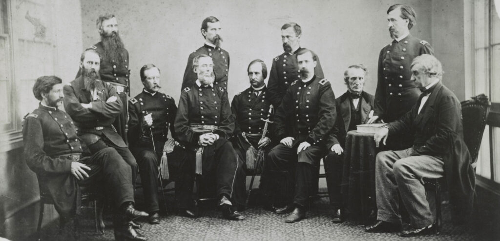 A group of twelve men in union army uniforms sitting together in a room.