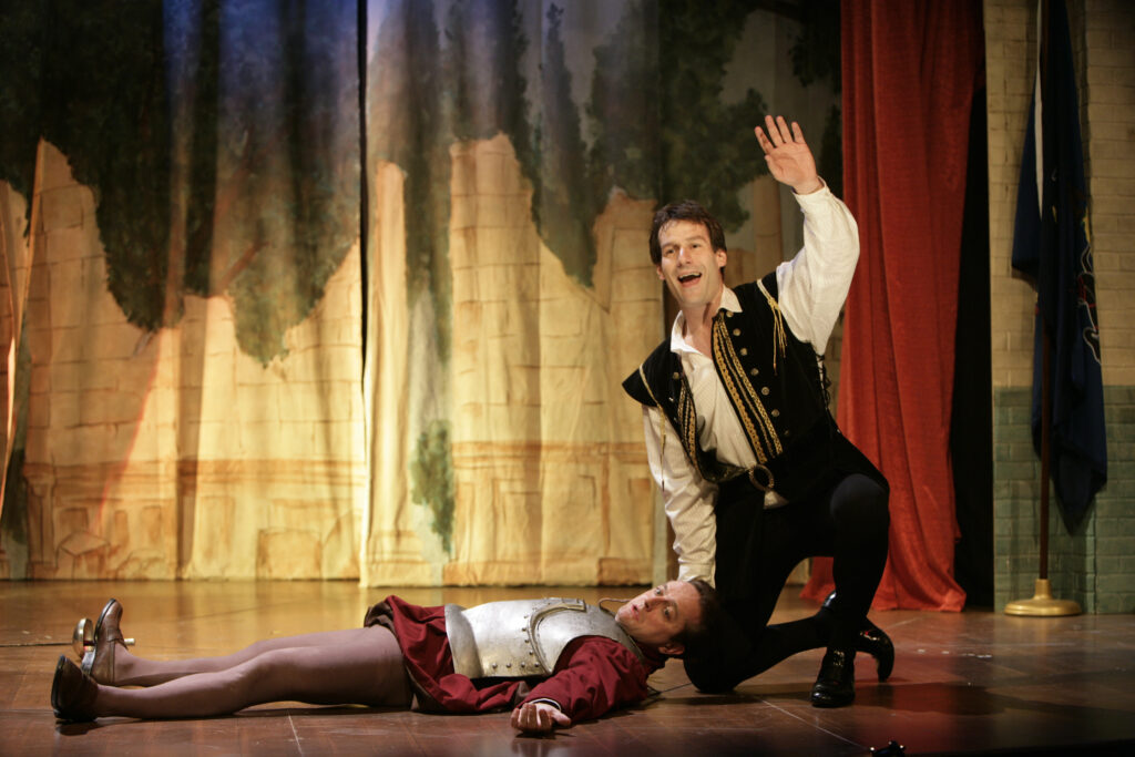 Two actors in Shakespearean dress perform a scene at a Moose Lodge.
