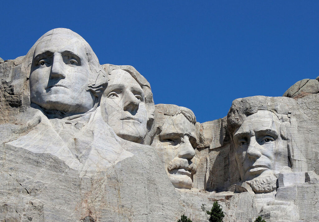 Four faces carved into the rocky cliffside of a mountain, depicting Presidents Washington, Jefferson, Theodore Roosevelt, and Lincoln.