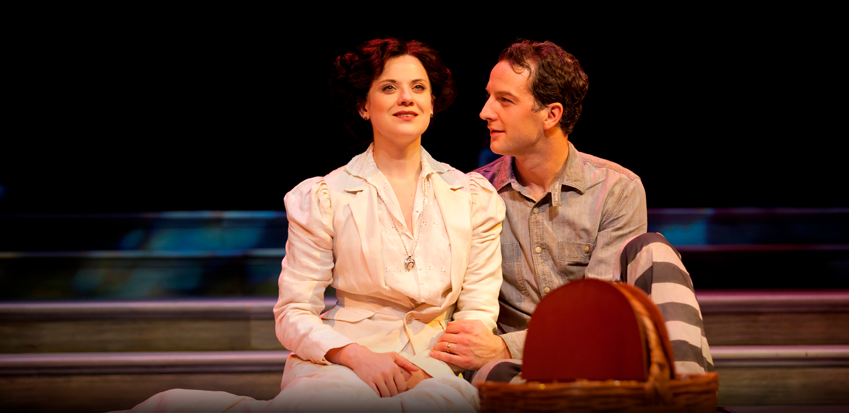 A man and woman sit together on the ground