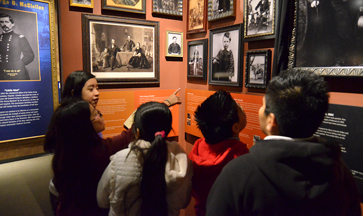 A group of four children talk while looking at an exhibit in the Ford's Theatre Museum.