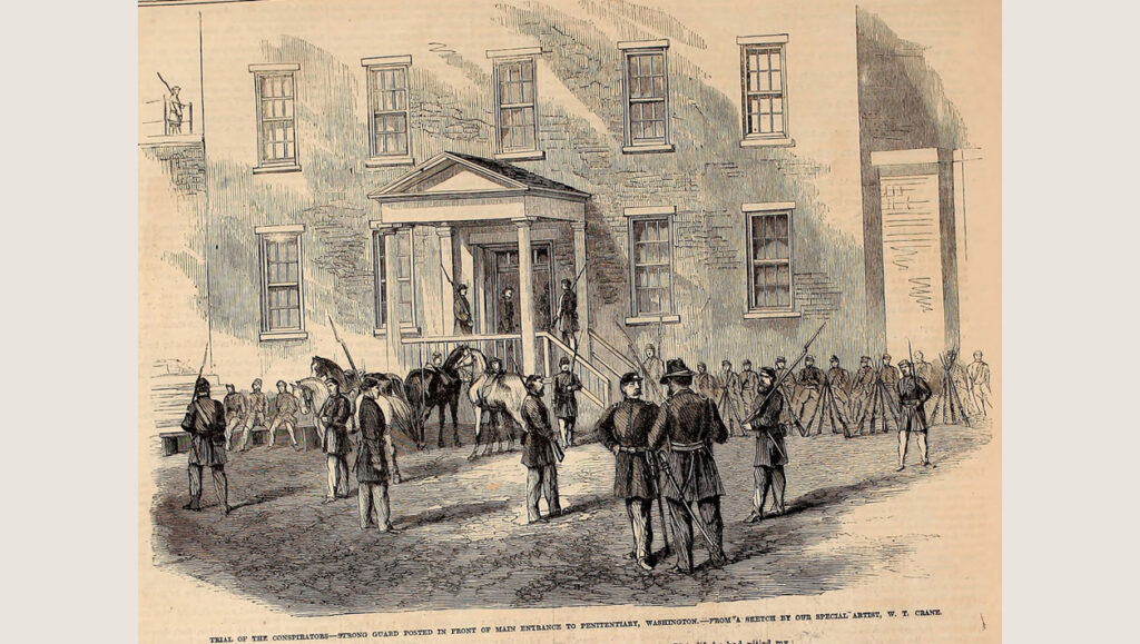 A drawing of a group of soldier guarding a large brick building. A caption reads" Trial of the conspirators - Strong guard posted in front of main entrance to penitentiary, Washington - From a sketch by our special artist, W. T. Crane.