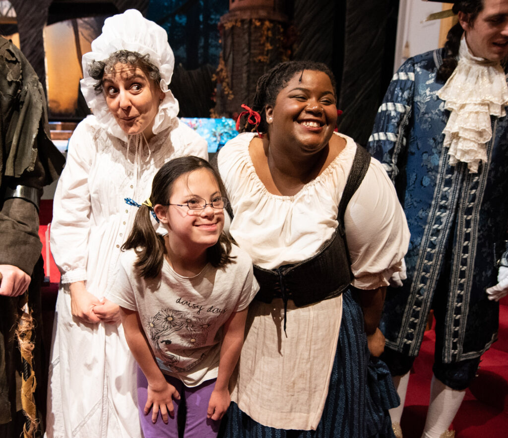 A child smiles as she poses with actors in costume at Ford’s Theatre.