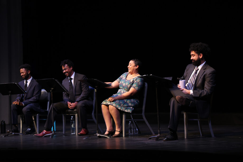 American Five 6 John Floyd as Bayard Rustin, Jay Frisby as Martin Luther King, Jr., Fatima Quander as Coretta Scott King and Noah Keyishian as Clarence Jones in the 2024 Ford’s Theatre reading of The American Five by Chess Jakobs, directed by Aaron Posner, with dramaturgy by José Carrasquillo. Photo by Andrew Buchsbaum. Four Black actors sit in chairs with music stands and scripts, smiling as they read a play.