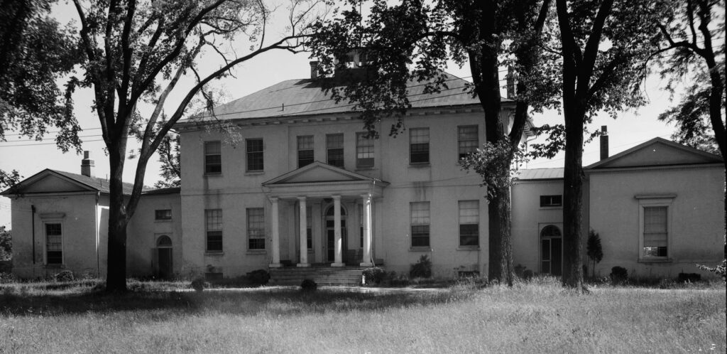 Black and white photograph of a large, antebellum plantation house.