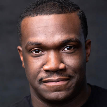 Headshot of a Black man in a black shirt.