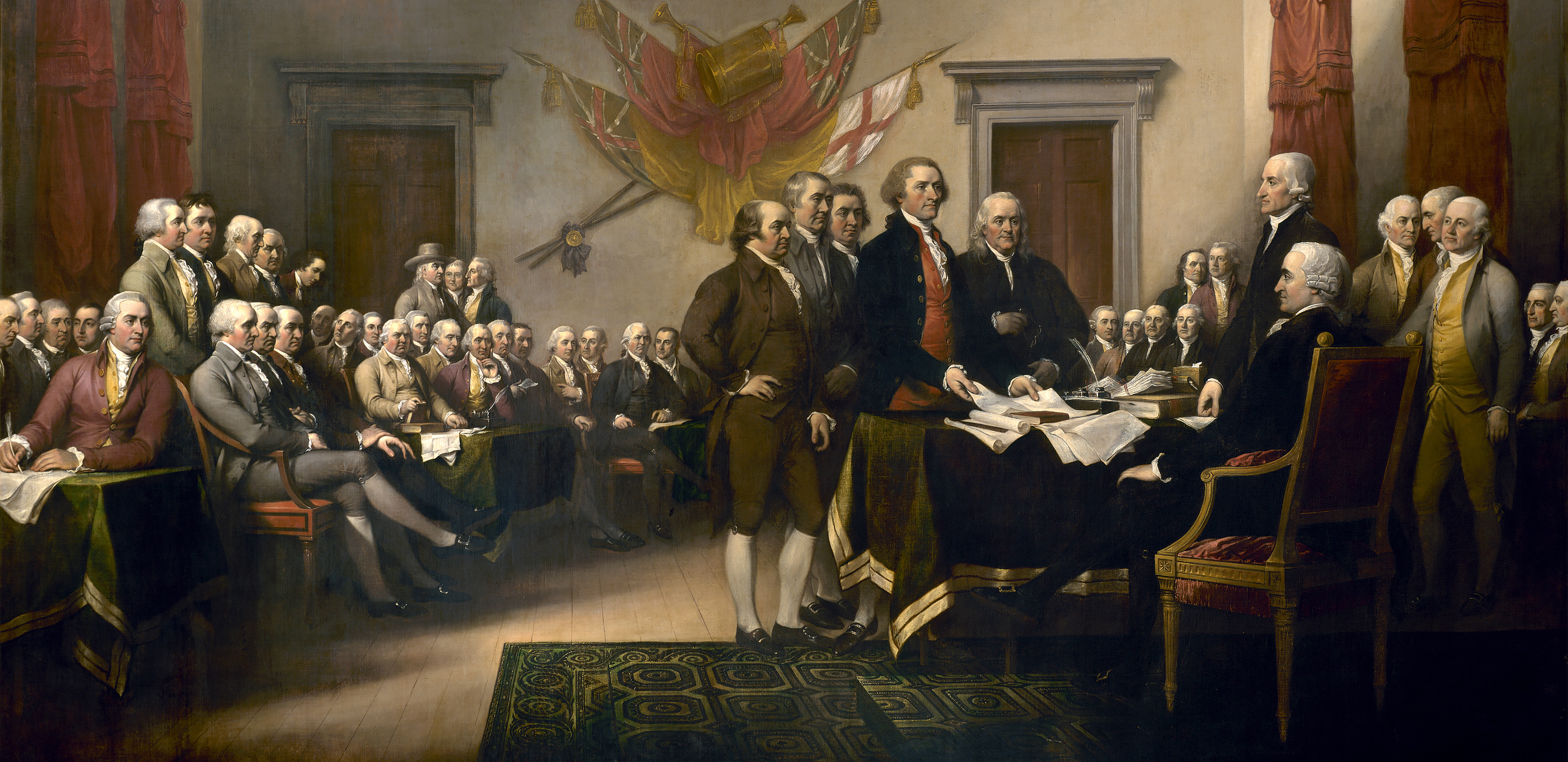 Painting of a large group of men dressed in 18th century clothing gathered in a meeting hall. Five men in the center present documents to a man seated behind a desk.