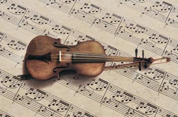 Image of a violin on top of a sheet of paper full of musical notations.