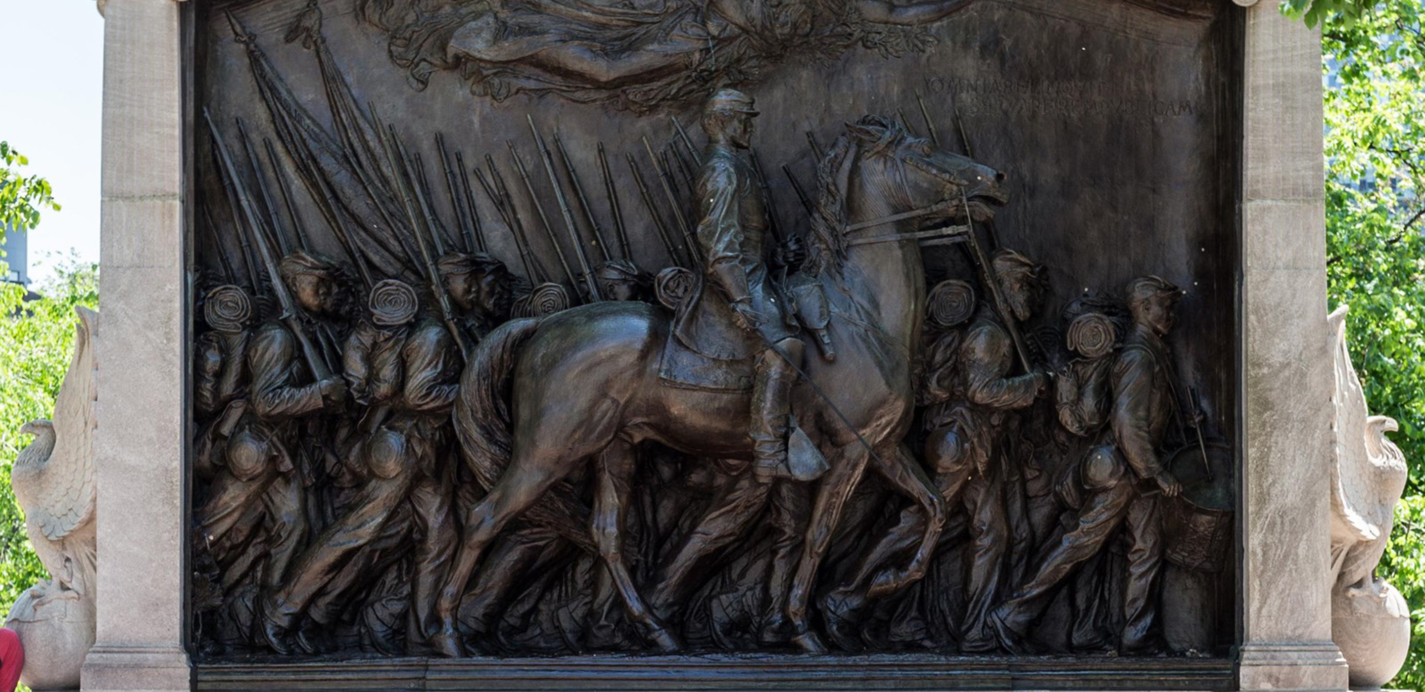 A bronze relief of a regiment of civil war soldiers, with the foreground dominated by an officer on horseback.